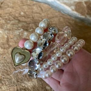 Assortment of Pearl and Clear bracelets.